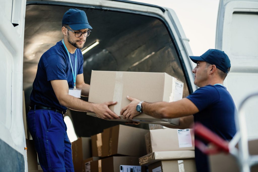 entregadores-carregando-caixas-de-papelao-em-uma-van-enquanto-se-preparam-para-o-embarque-scaled Entrega-rapida